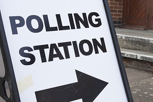 A sign with the words "POLLING STATION" and an arrow pointing to the right